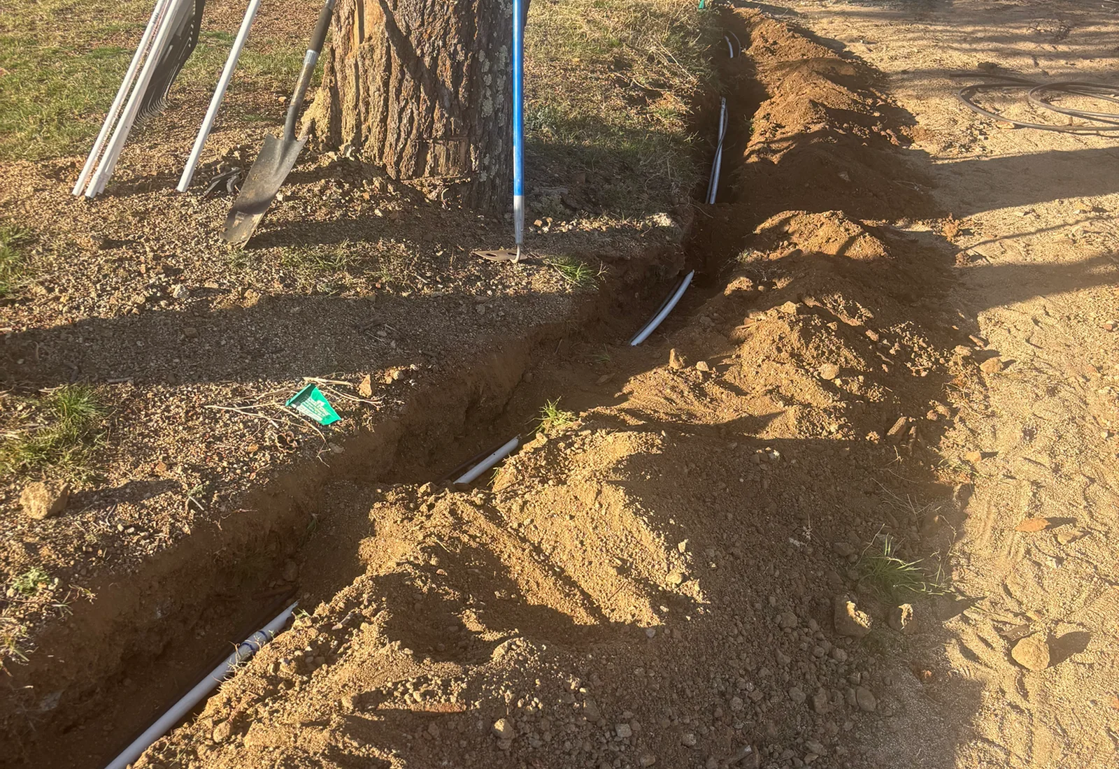 Underground plumbing pipe installation in an open trench