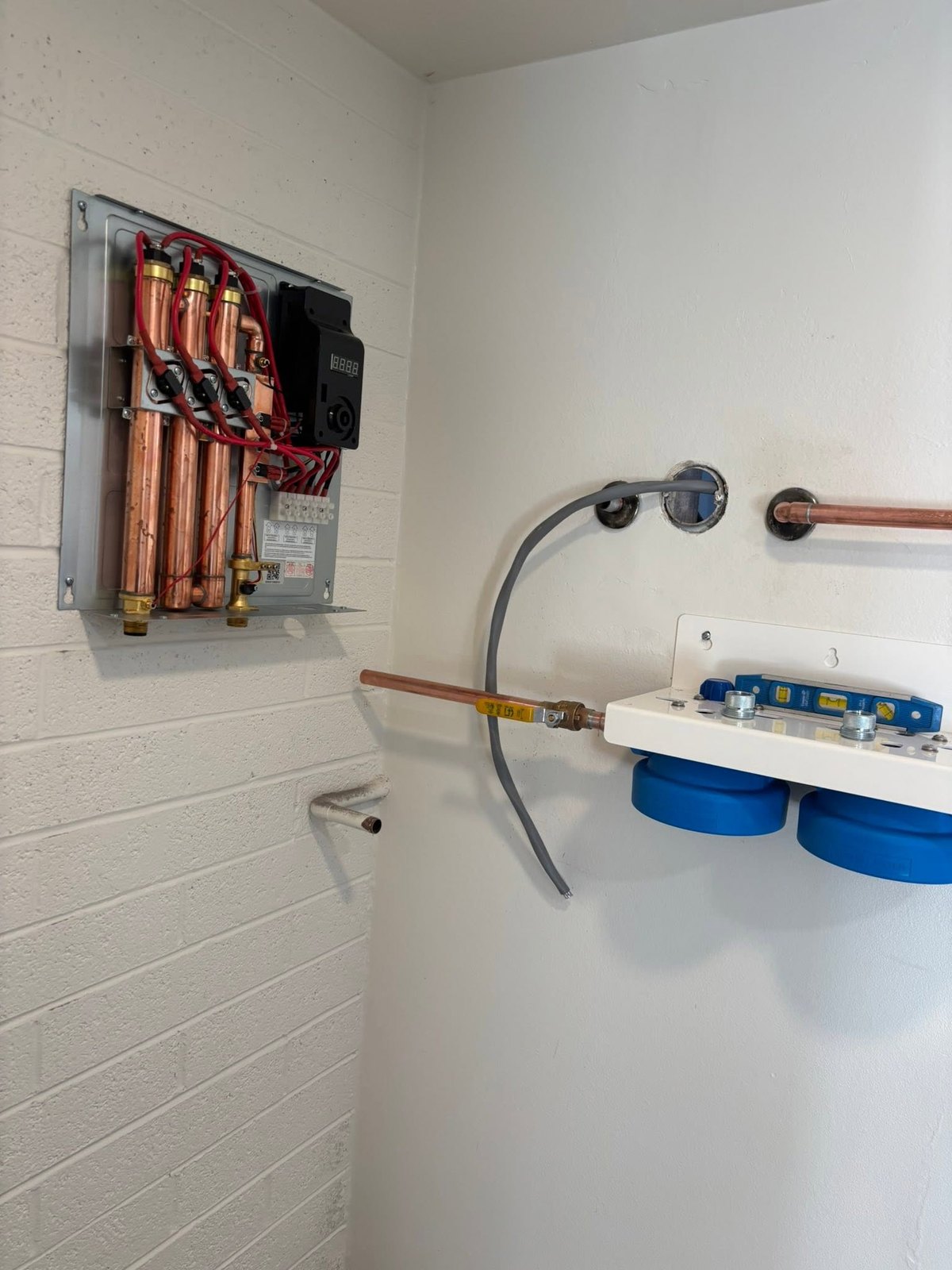 Tankless water-heater components beside blue water-filtration equipment