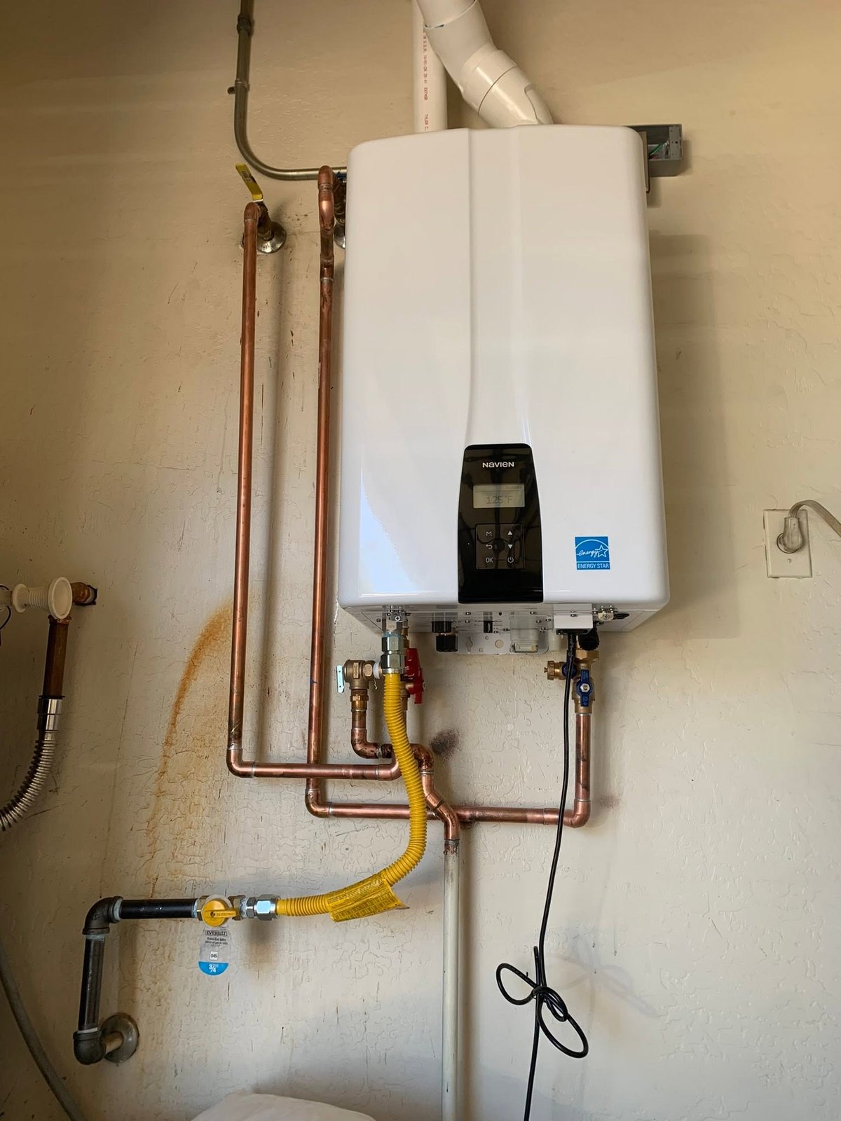 Tankless water heater with copper piping, gas line, and PVC venting