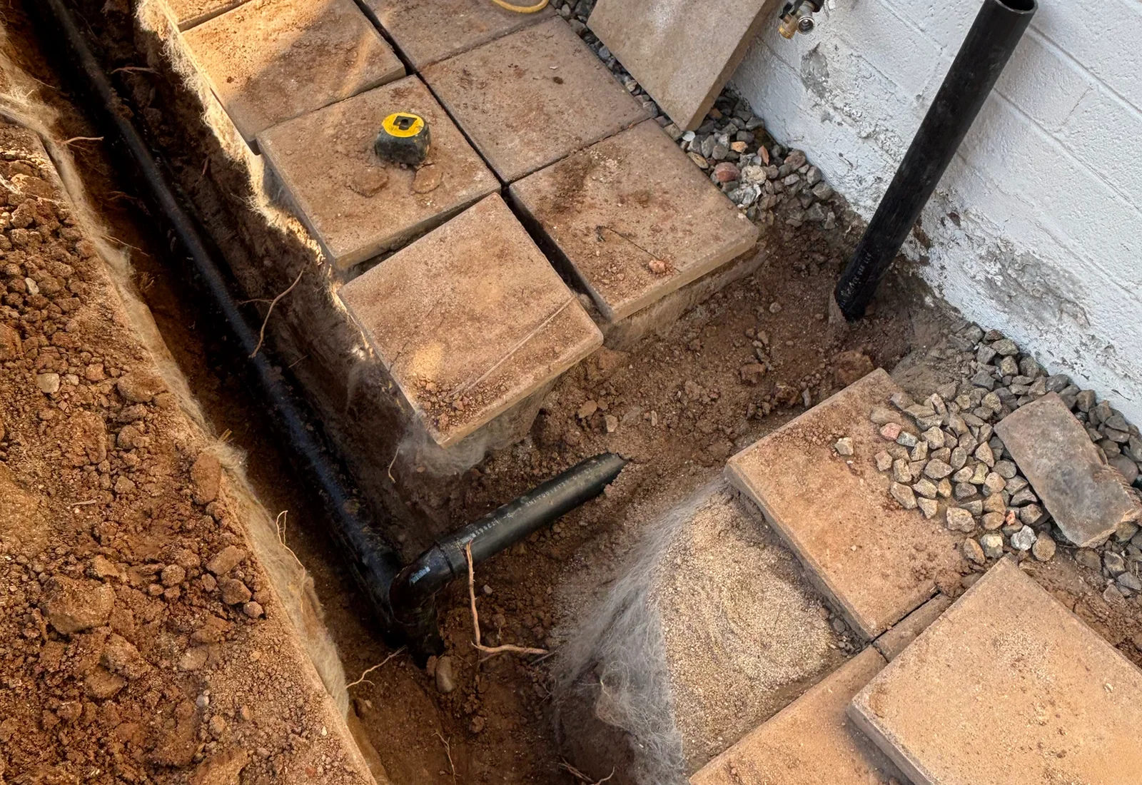 Exterior underground plumbing repair area with exposed piping
