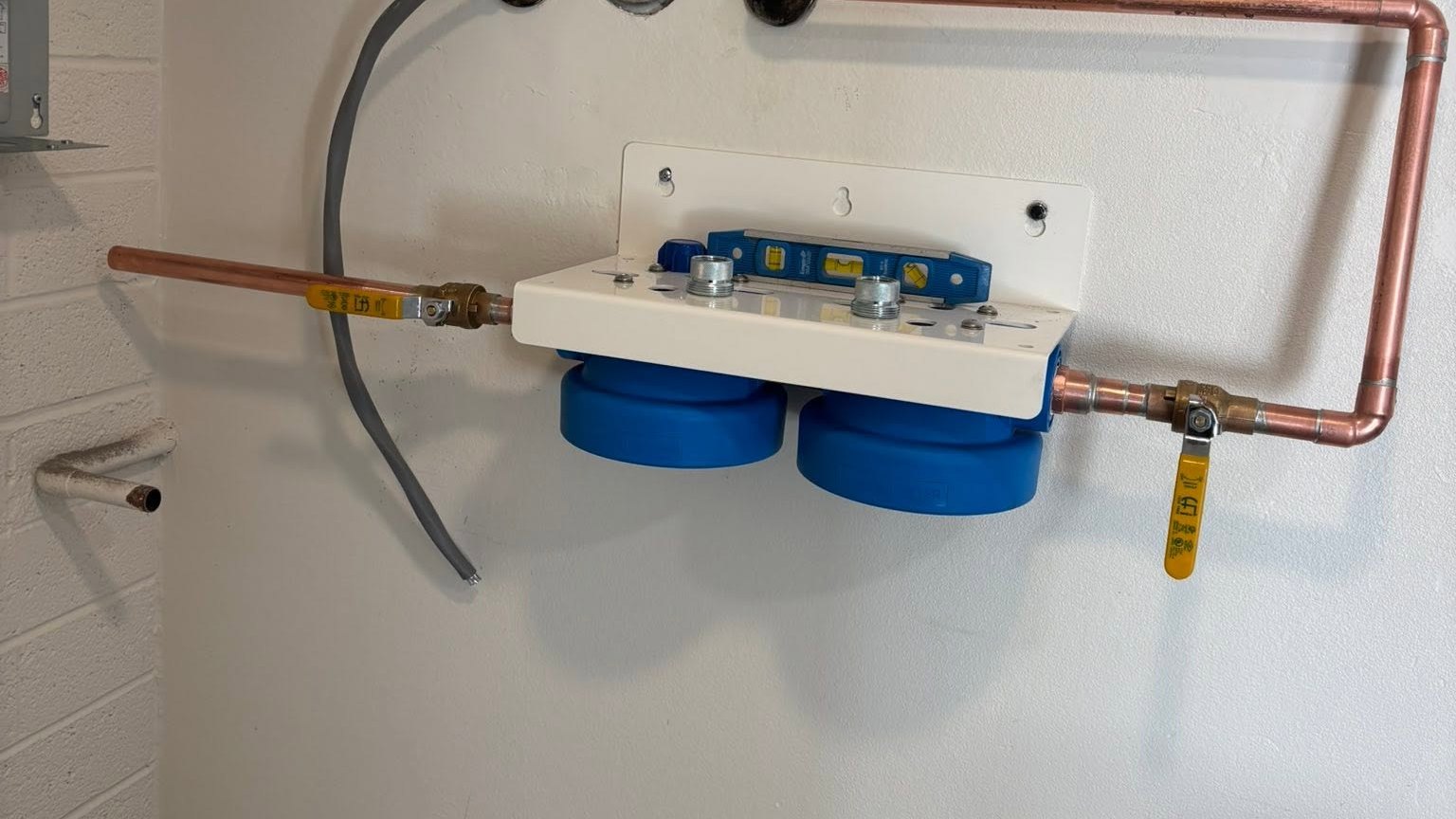 Wall-mounted water-treatment equipment with connected copper piping